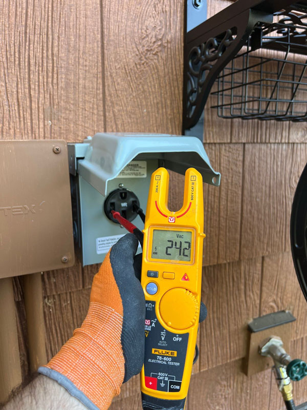 Melby Electric testing voltage at outdoor outlet on home wall